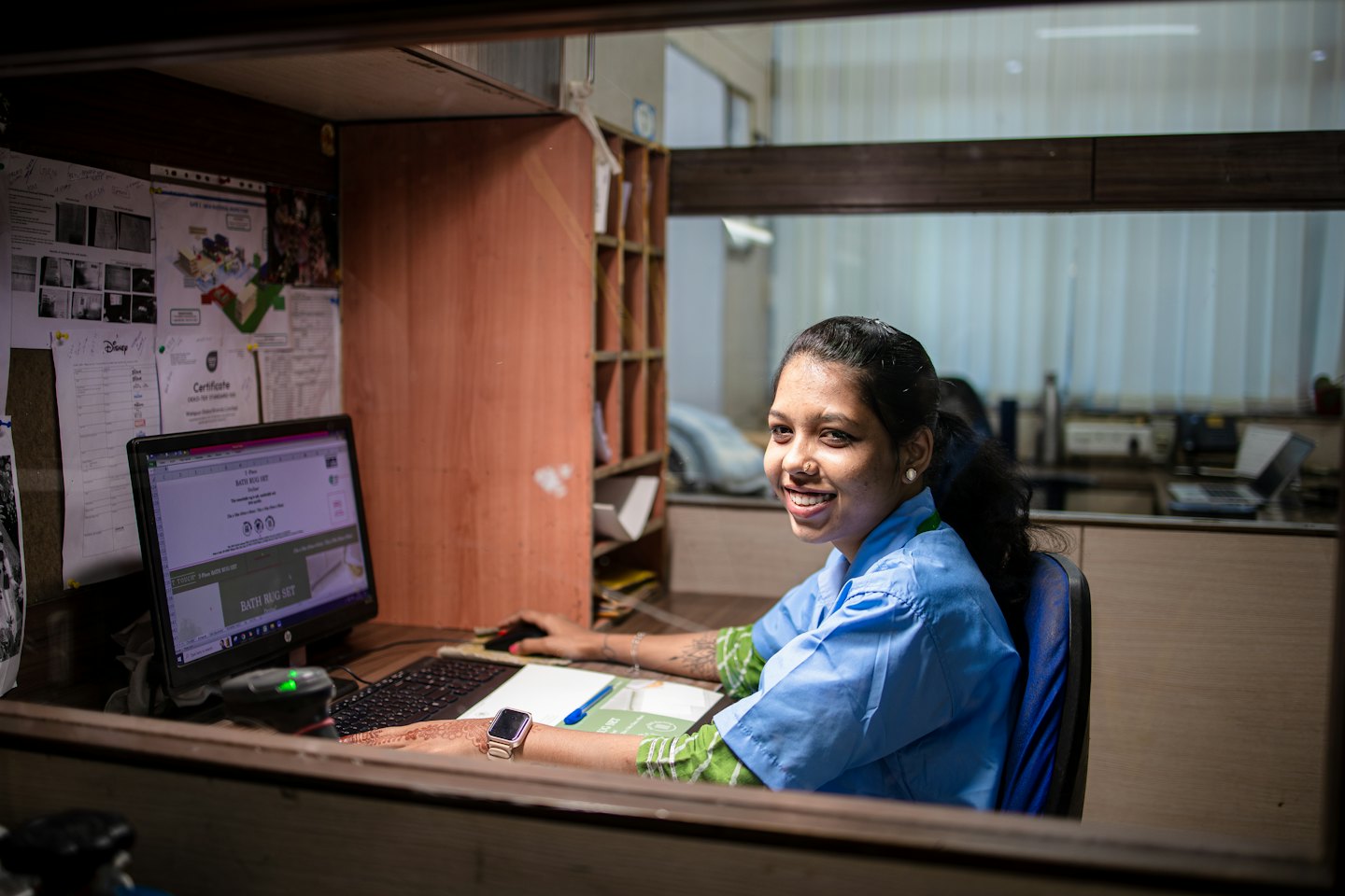 Frau in blauer Uniform arbeitet an ihrem Bürocomputer.